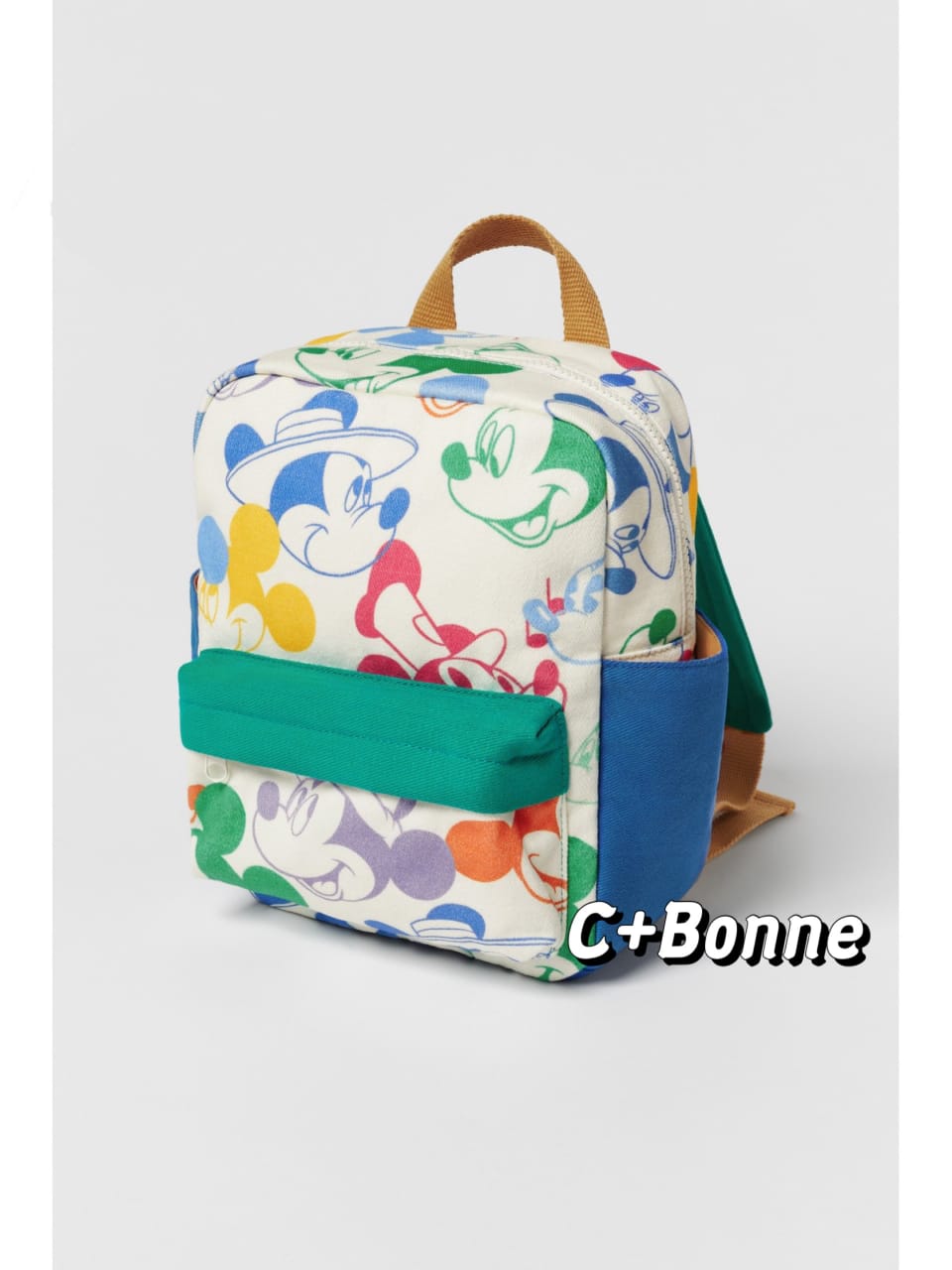 Matching Mickey Mouse print backpack in white canvas with vibrant patchwork character design featuring green pocket and brown handles - colorful multi-functional kids school bag with rain cover