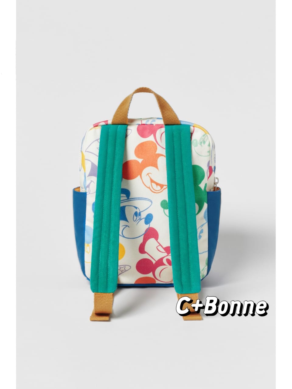 Matching Mickey Mouse print backpack in white canvas with vibrant patchwork character design featuring green pocket and brown handles - colorful multi-functional kids school bag with rain cover