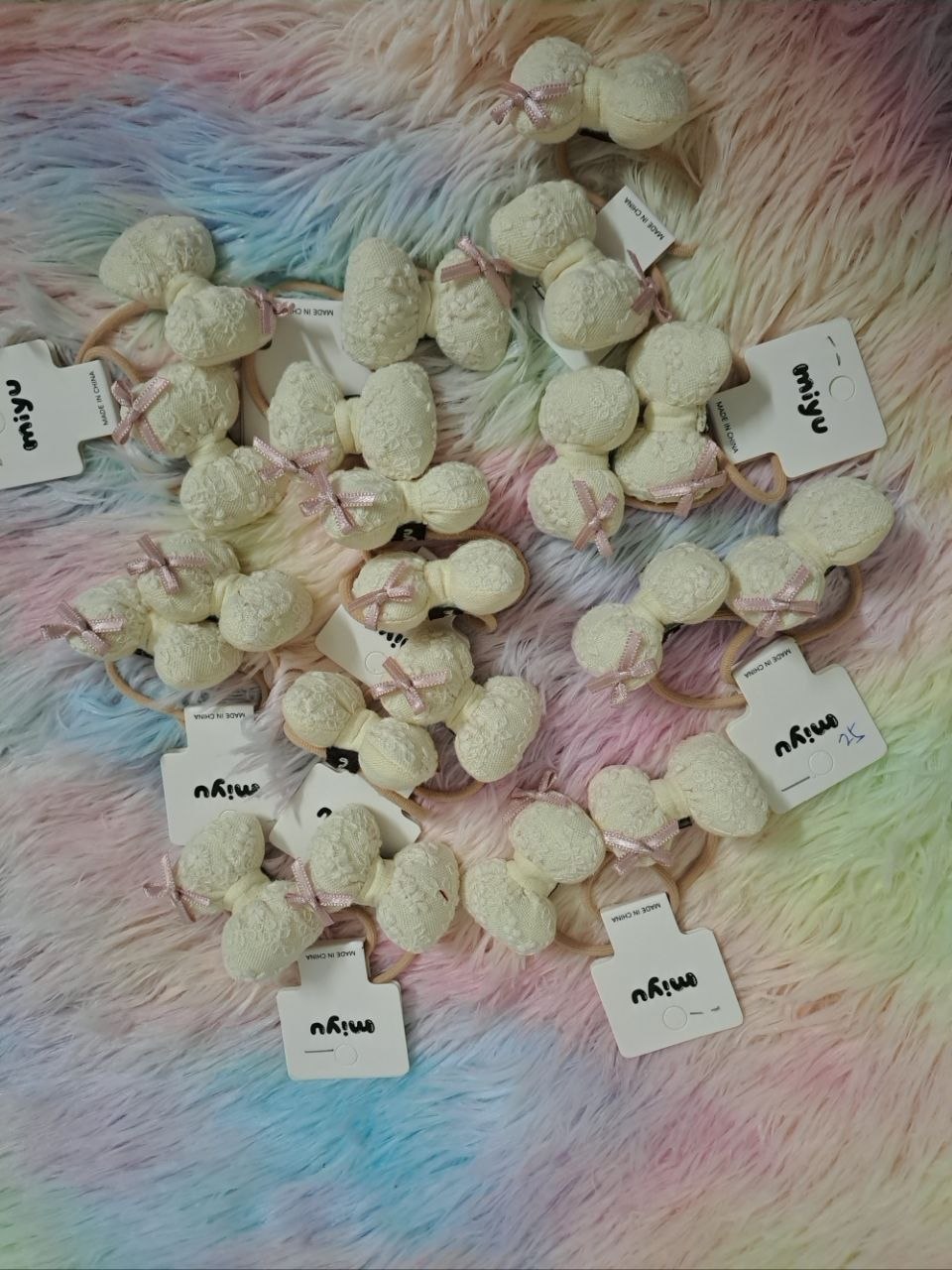 Miyu brand cream-colored fabric bow hair ties with textured lace material and pink ribbon accents for girls
