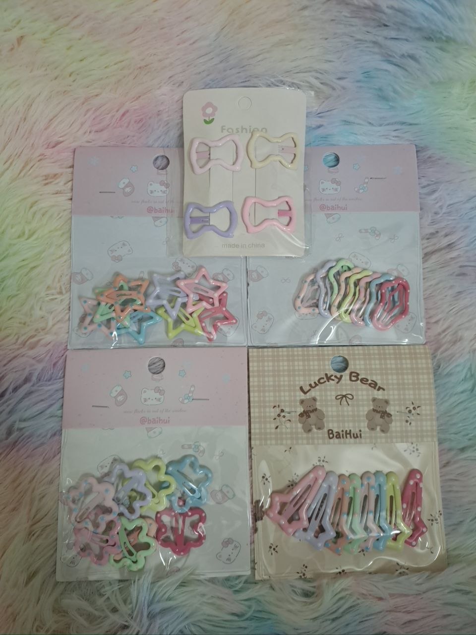 Assorted hair clip collection including pastel bows, rainbow star cutouts, and colorful butterfly clips for girls