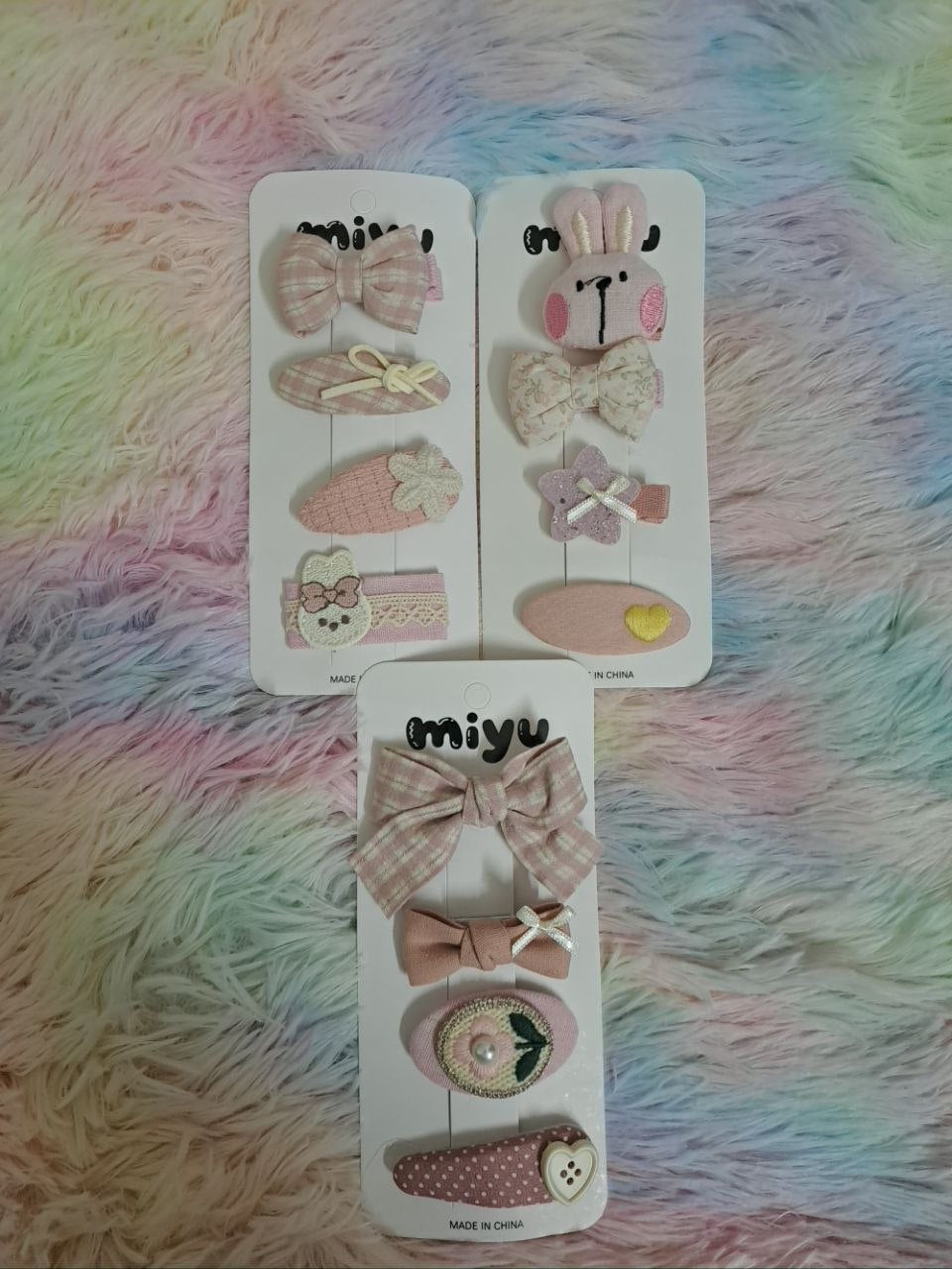 Miyu brand coordinated fabric hair clips including gingham bows, bunny face, ribbons, and embellished pieces in pink and cream tones for girls