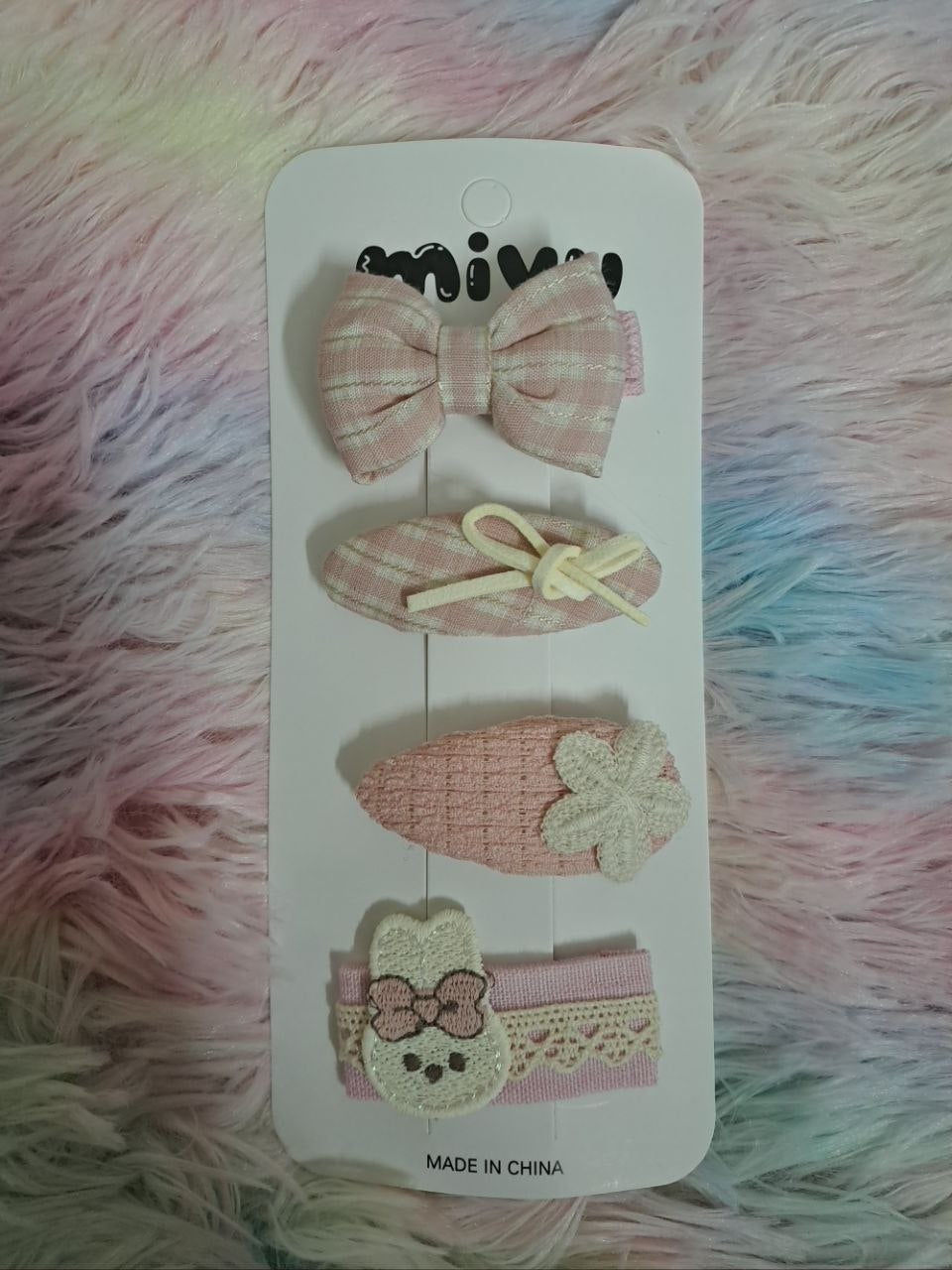Miyu brand coordinated fabric hair clips including gingham bows, bunny face, ribbons, and embellished pieces in pink and cream tones for girls