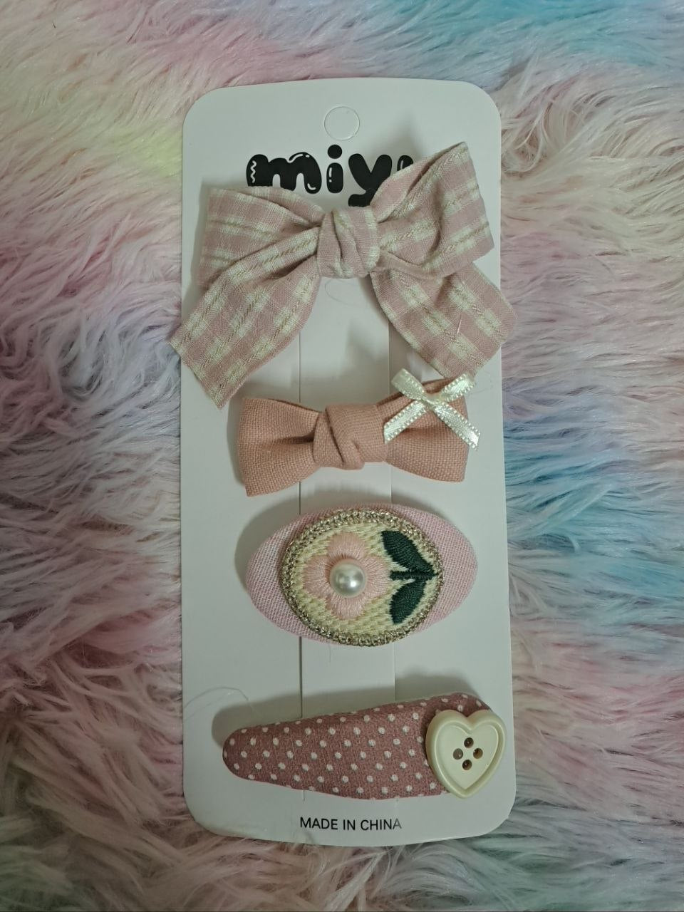 Miyu brand coordinated fabric hair clips including gingham bows, bunny face, ribbons, and embellished pieces in pink and cream tones for girls