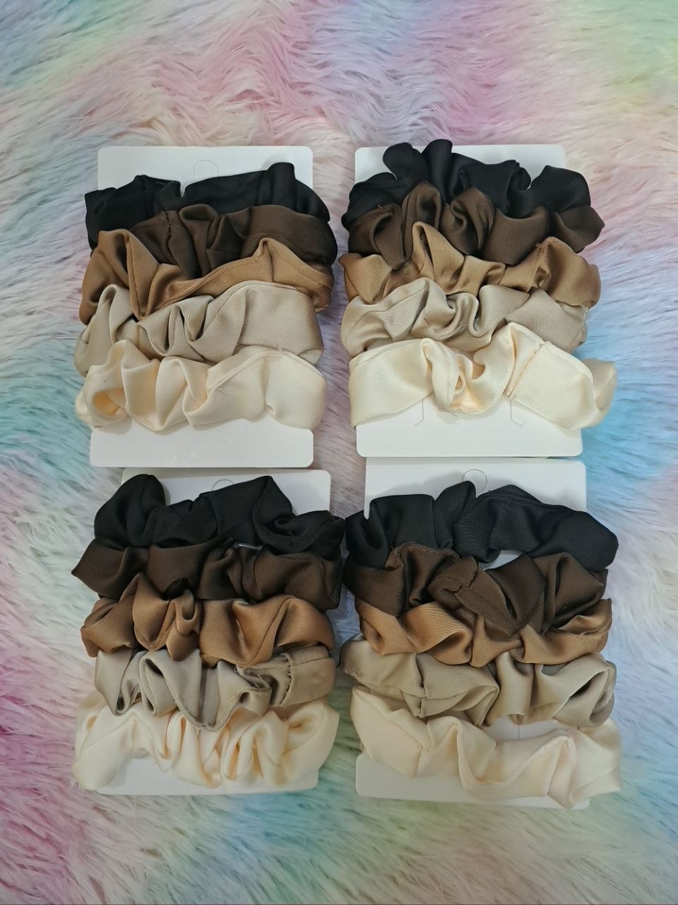 Satin scrunchies in coordinated neutral tones including black, brown, tan, and cream for versatile elegant styling for girls