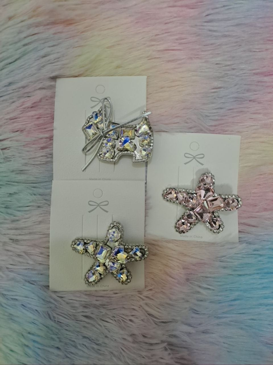 Large statement hair clips in butterfly and flower shapes completely covered with sparkling rhinestones in clear, pink, and holographic colors for girls
