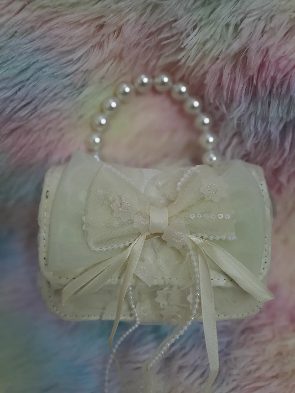 Cream evening bag with lace overlay, pearl bead handle, tulle bow with embroidered floral details and pearl accents for girls
