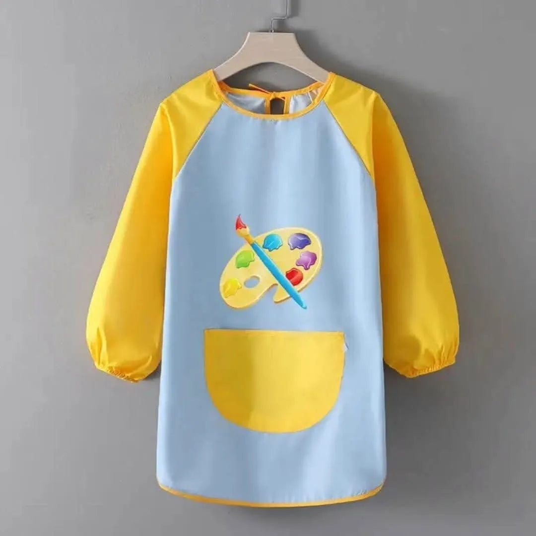 Blue and yellow waterproof children's art smock with paint palette and brush design hanging on wooden hanger against gray background