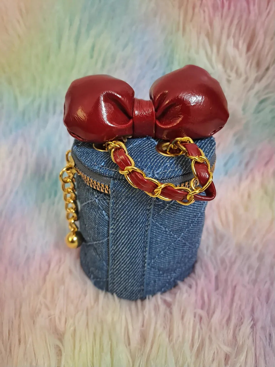 Blue denim cylinder bag with burgundy red boxing glove closure and gold chain strap for girls
