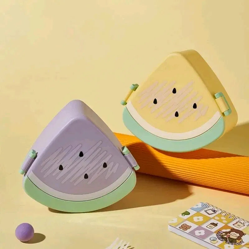 Watermelon slice shaped kids lunch box in purple-and-mint and yellow-and-mint colourways, with moulded seed embossed details, green rind edge, hinged flip-top lid and side clip latches, BPA-free novelty fruit tiffin box