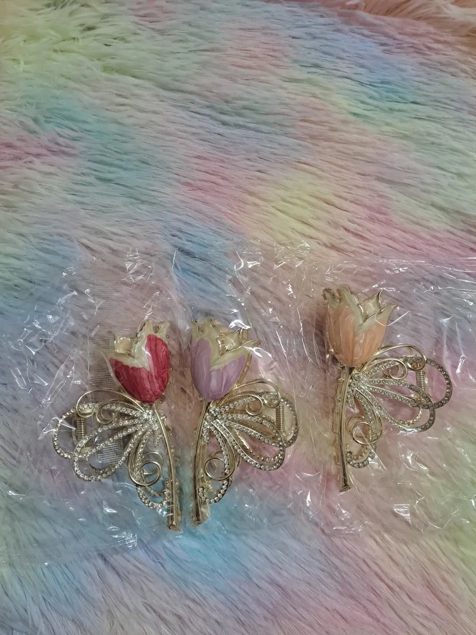 Tulip flower rhinestone butterfly hair clip in three colourways: crimson red, soft lilac purple, and delicate peach, with gold filigree radial butterfly wings set with rhinestones and sculpted resin tulip centrepiece, elegant occasion hair barrette
