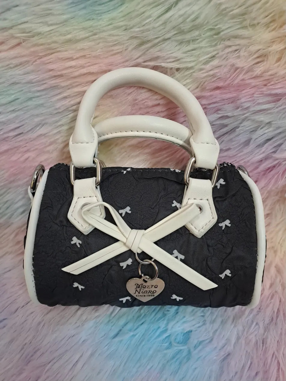 Mazra Niaro black quilted mini handbag with white bow pattern, white trim, decorative bow and shoulder strap for girls
